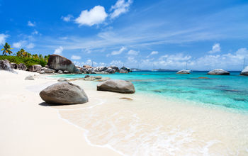 Beautiful tropical beach with white sand, turquoise ocean water and blue sky at Virgin Gorda, British Virgin Islands in Caribbean (Photo via shalamov / iStock / Getty Images Plus)