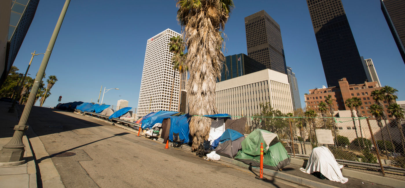 Image: A homeless encampment next to a Downtown Los Angeles freeway. (Photo Credit: MattGush / iStock / Getty Images Plus)