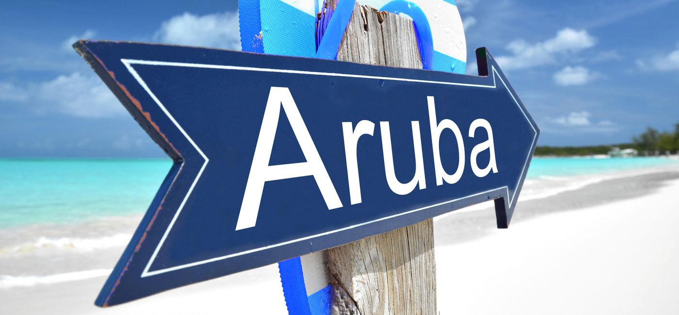 Image: Aruba sign on the beach. (photo via Pincasso / iStock / Getty Images Plus)