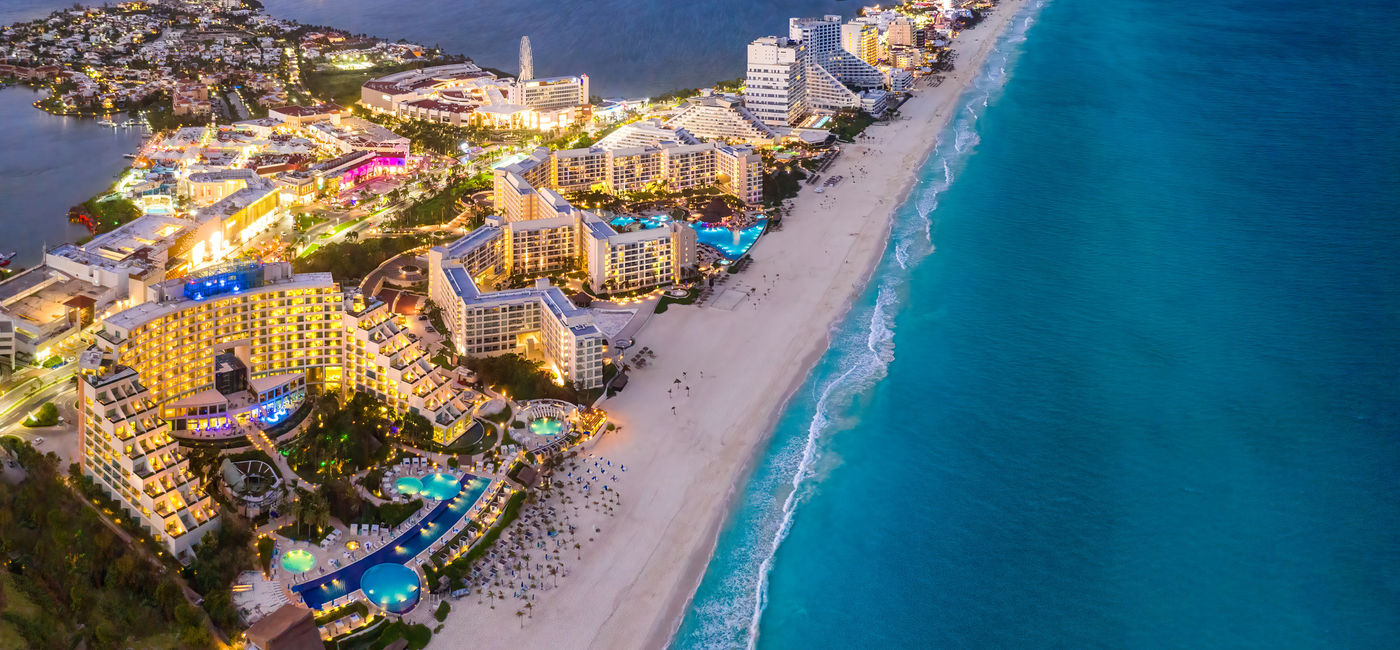 Image: Cancun's Hotel Zone at sunset, Quintana Roo, Mexico. (photo via Jonathan Ross / iStock / Getty Images Plus)