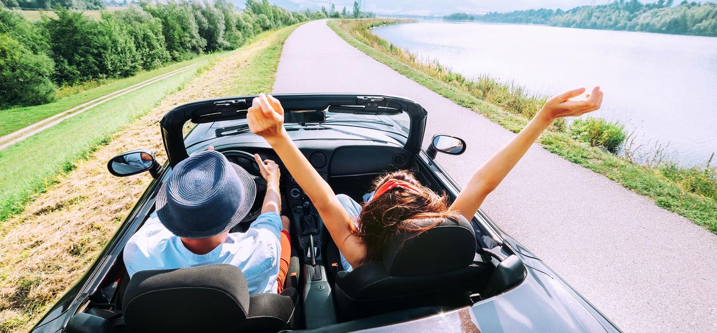 Image: Couple riding in a convertible. (Photo Credit: Solovyova /iStock / Getty Images Plus)