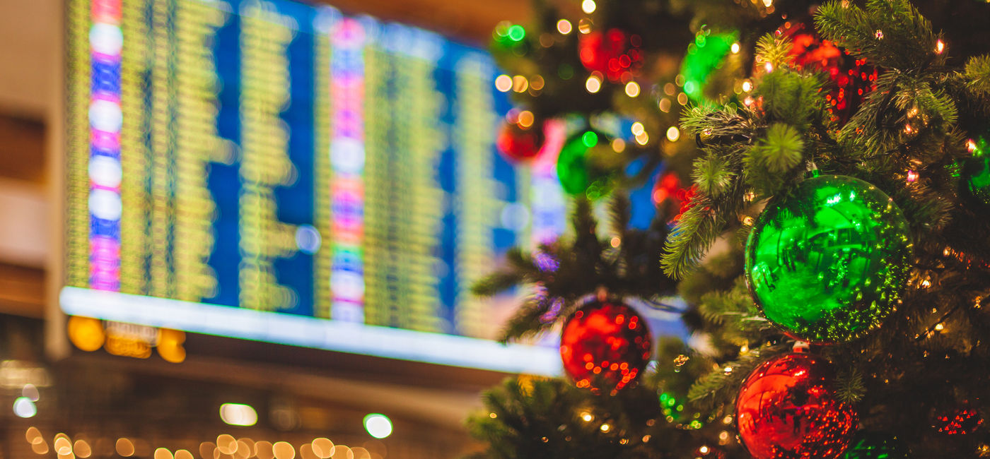 Image: PHOTO: Christmas tree in front of an airport departures board. (Photo via iStock/Getty Images Plus/Visionkick)