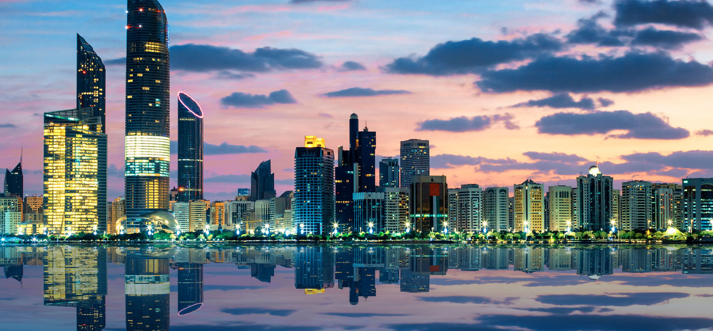 Image: View of Abu Dhabi Skyline at sunset, United Arab Emirates (photo via vwalakte/iStock/Getty Images Plus)