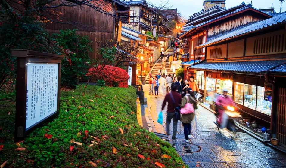 Tourists walk on a street leading to Kiyomizu-dera Temple in Kyoto, Japan