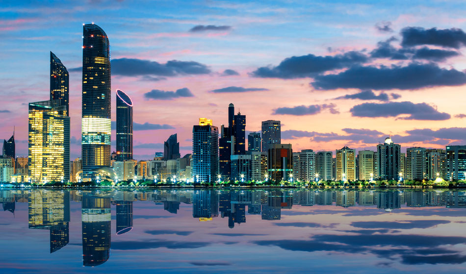 View of Abu Dhabi Skyline at sunset, United Arab Emirates (photo via vwalakte/iStock/Getty Images Plus)