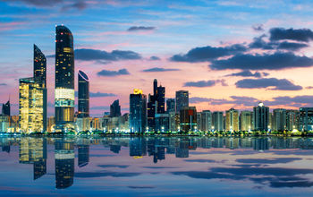 View of Abu Dhabi Skyline at sunset, United Arab Emirates (photo via vwalakte/iStock/Getty Images Plus)