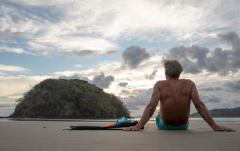 Man with snorkeling equipment relaxes on beach in Panama in the morning 