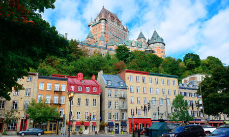 Chateau Frontenac in the day with colorful buildings on street in Quebec City (Photo via rabbit75_ist / iStock / Getty Images Plus)