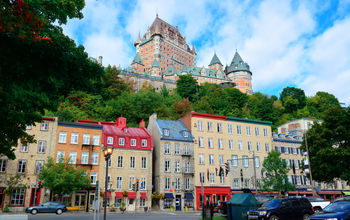 Chateau Frontenac in the day with colorful buildings on street in Quebec City (Photo via rabbit75_ist / iStock / Getty Images Plus)