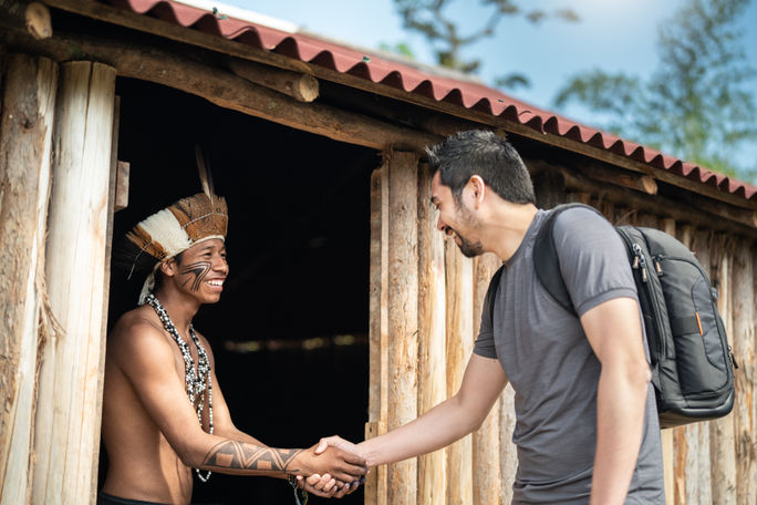 Tourist interacting with indigenous Brazilian young man.